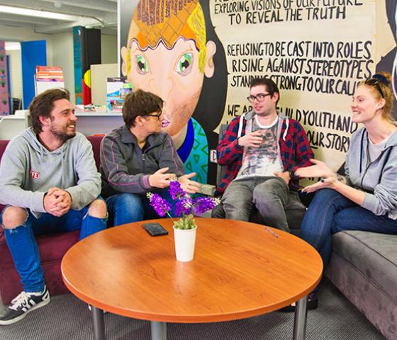 Four young people sitting on sofas talking