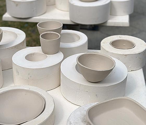 a selection of white clay pots and bowls