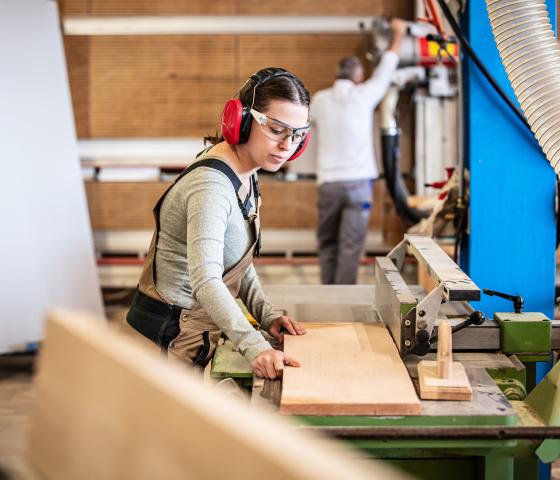 Decorative image - Female carpenter using saw 